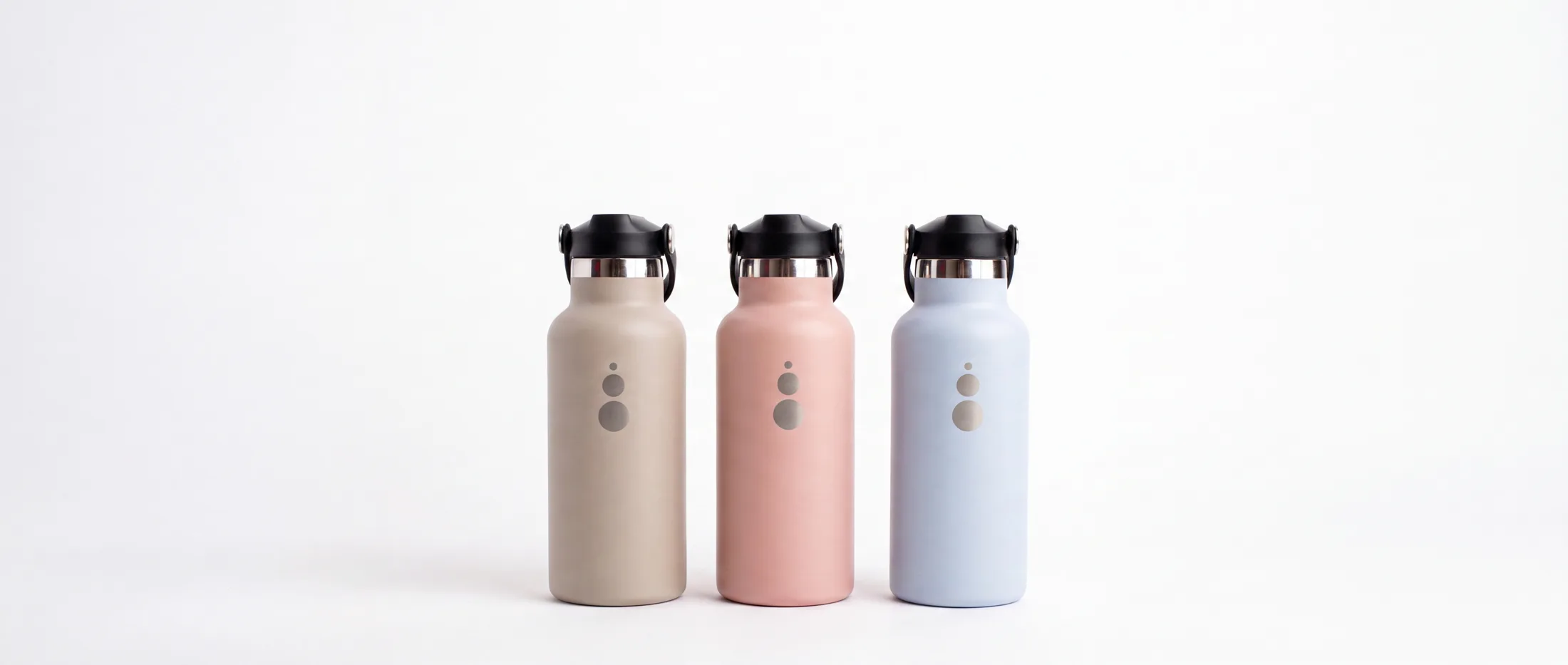 Las tres botellas WaterGo en fila sobre fondo blanco: acabado Nude, acabado Pink y acabado Blue.
